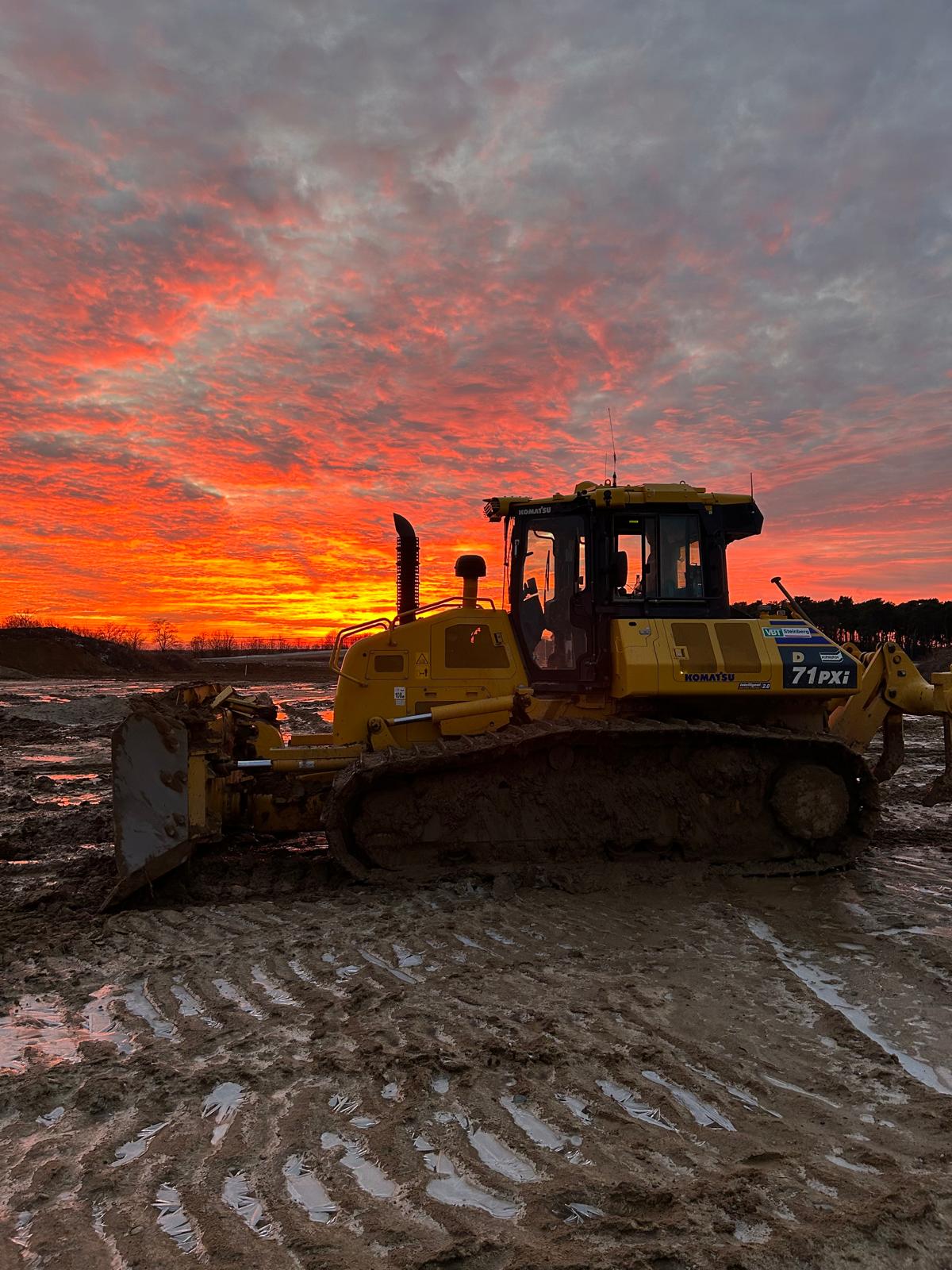 Planierraupe auf Baustelle bei Sonnenuntergang