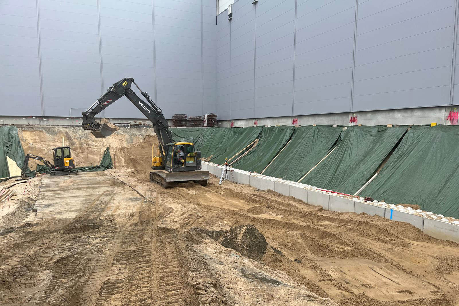 Hallenbau mit Bagger auf der Baustelle